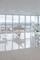 a white and very bright luxury fashionable apartment on a high floor with a free layout, a living room with expensive furniture and panoramic glazing