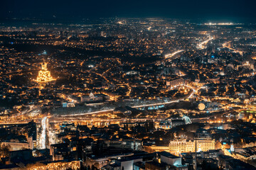 Fototapeta na wymiar Georgia capital Tbilisi night city view, illuminated historical district, aerial
