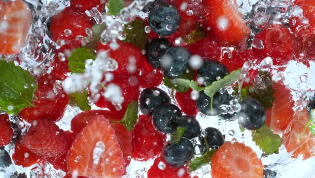 Super Slow Motion Shot of Fresh Berries Falling into Water Whirl at 1000 fps.
