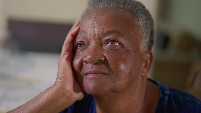 Close-up face of a pensive African American Elderly Woman Sitting at Home, Lost in Daydream