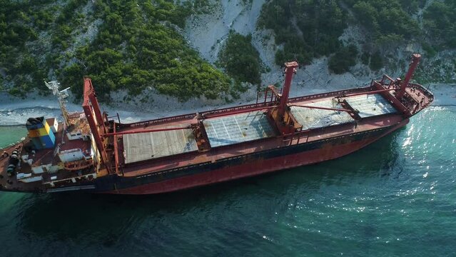 Aerial view of abandoned cargo ship. Bulk carrier ran aground after the storm. Dry cargo ship stands ashore.