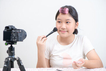 cute asian girl blogger is showing how to make up and use cosmetics. I