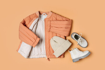 Stylish terracotta children's autumn jacket, knitted hat and boots. Fashion kids outfit for for spring, autumn or winter. Flat lay, top view