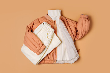 Stylish terracotta children's autumn jacket with knitted sweater and  trousers. Fashion kids outfit...