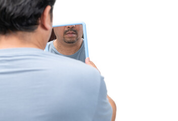 Bearded man looking in the mirror for skin tags or acrochordon on his neck