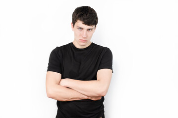 Obraz premium Young sad guy on light background in a dark t-shirt, suffering from anxiety and headache, stressed from studying at college, does not understand why he is studying there