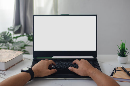 man's hands working on laptop at home desk
