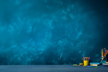 colorful school supplies on blue background, in the classroom. back to school. copy space. generative ai