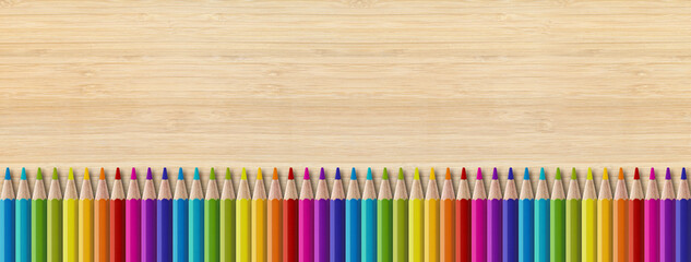 Colored pencil group isolated on wooden background. Panoramic banner background