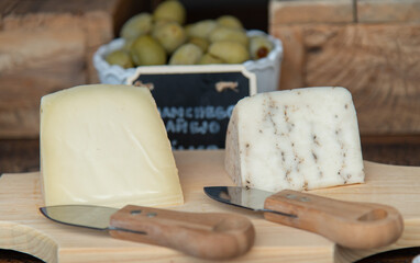 Queso Manchego, sobre tabla de madera con cuchillo 