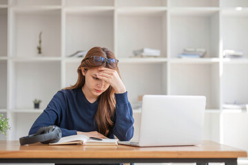 Asian women are bored from their online studies, have a sad face and have been tired from their...