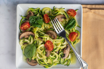 zucchini noodles  top with  tomatoes spinach  and mushrooms