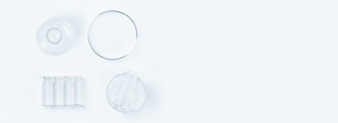 a set of laboratory glassware on a light background. Petri dishes, flasks, cups.