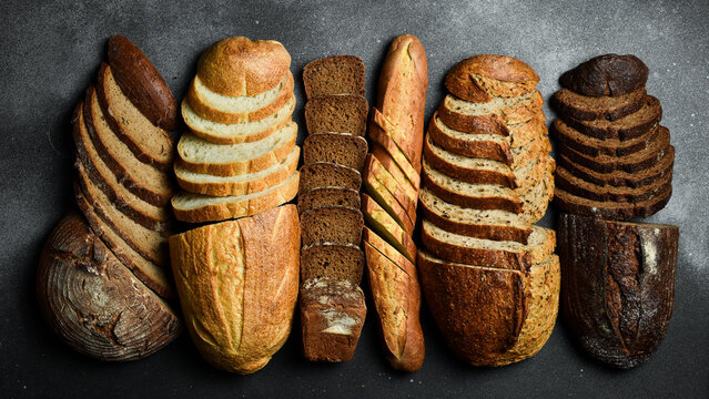 Banner with the image of different types of bread. Assortment of rye, bran and sourdough bread. Top view.