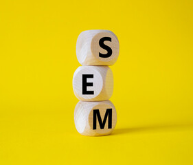 SEM - Search Engine Marketing symbol. Wooden cubes with words SEM. Beautiful yellow background. Business and SEM concept. Copy space.