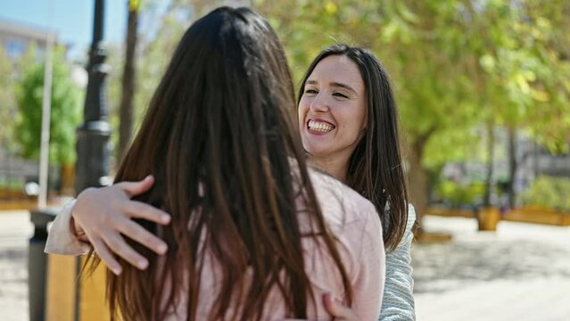 Two women hugging each other at park