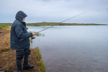 Fisherman catching coho salmon in Egegik river in Alaska. The fish are in abundant supply in Alaskan water.