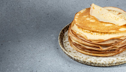 Thin crepes on a plate. Delicious breakfast or dessert. Long banner format. top view