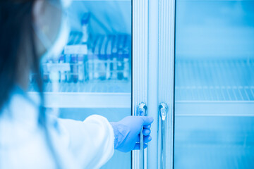 Close up scientist hand wear blue gloves opening storage reagent container for laboratory...