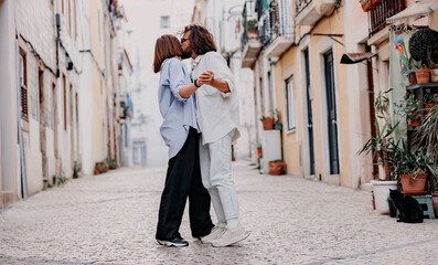 Couple in love dancing and kissing on city street during summer vacation