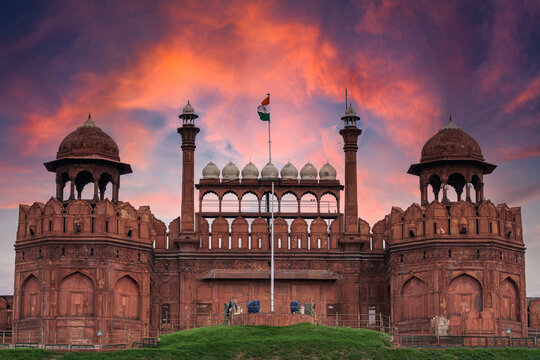 Red Fort or Lal Qila in Delhi with indian flag on foreground with moody sk.UNESCO World heritage site. Discover the India. Open world after covid-19