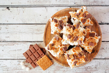 Smores brownies dessert platter. Above view on a rustic white wood background.