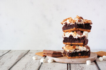 Stack of smores brownie dessert bars. Side view table scene with a white background. - obrazy, fototapety, plakaty