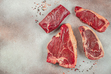 set of various uncooked stakes t bone tomahawk sirloin ribeye beef on a light background. banner,...