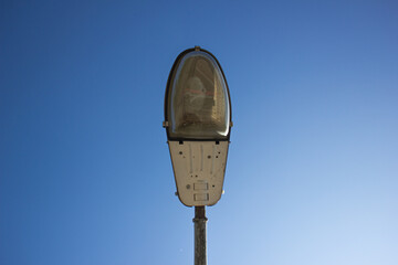 Old street lamp. Damaged street lighting. Lamppost during the day.