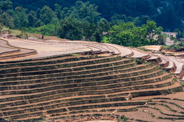 The pouring water season makes the terraced fields of Y Ty commune, Lao Cai province, Vietnam appear with brown soil blending with the beautiful sky.