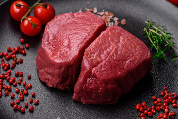 Raw beef eye steak round with salt, spices and herbs