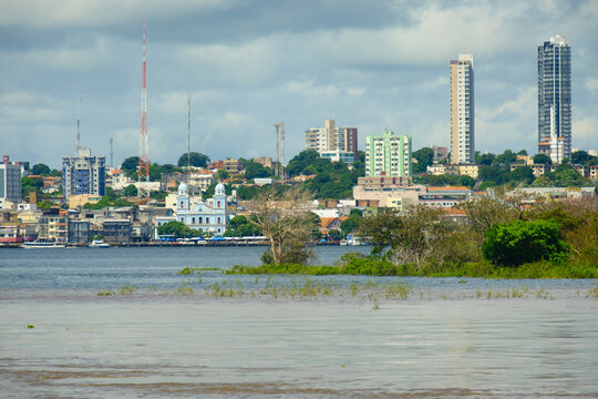cruising the amazon river view of Santarem city at distance from a boat Brazil