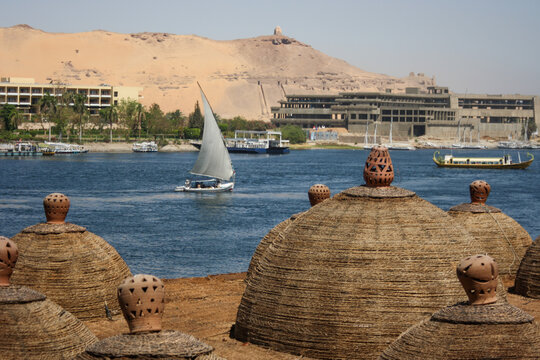 barca de vela t&iacute;pica del Nilo navegando con edificios de fondo