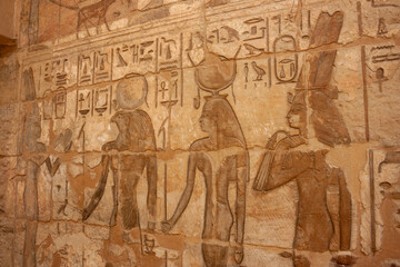 Pared de un templo egipcio con jeroglíficos y dioses representados como Horus  - obrazy, fototapety, plakaty
