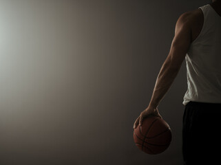 Rear view of a basketball player in the empty gym with copy space