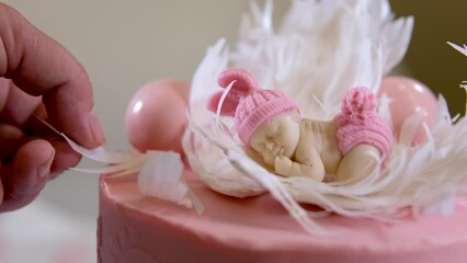 cooking decoration of a delicious pink cake for festive birth of a child and christening legs prints on the side of the dessert