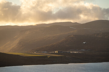 Plane landing in Faroe Islands on Vagar Airport during amazing sunset