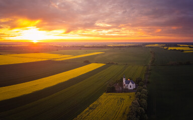 Fototapeta na wymiar Spring sunset over polish province, fields and a church aerial photo