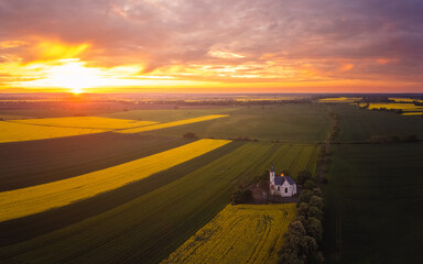 Spring sunset over polish province, fields and a church aerial photo - obrazy, fototapety, plakaty