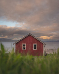 Red cottage of the Norwegian culture and architecture in Norway, with dynamic sunset sky © Zbigniew Wu