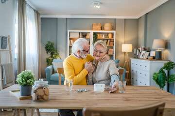 senior couple at home woman check blood pressure husband sit beside