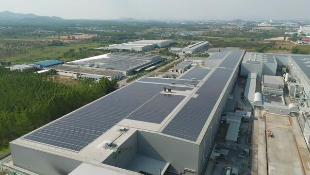 Aerial view of solar panels or solar cells on the roof of factory building rooftop. Power plant, renewable clean energy source. Eco technology for electric power in industry.