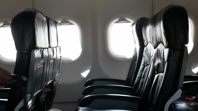 view to the airplane window with empty seat in daytime inside airplane cabin