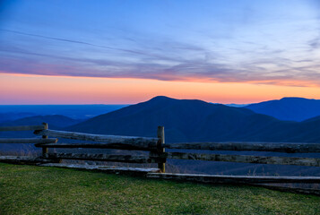 Colorful Sunset over Three Ridges Mountain seen from Devils Knob with split rail wooden fence in foreground