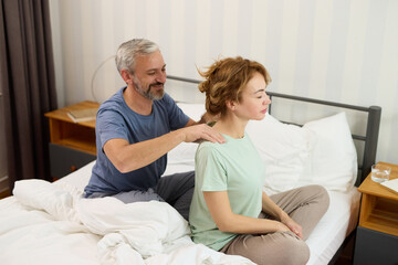 Man giving a shoulder massage to his wife bedroom