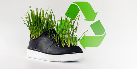 Environment conservation concept, recycling and reuse, green grass growing from rubber shoe.