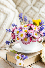 Fototapeta na wymiar Greeting card for Women's or Mother's Day, 8th of March. Beautiful spring or summer floral composition with daisy camomile flowers in a white cup for countryside table decor. Wooden background