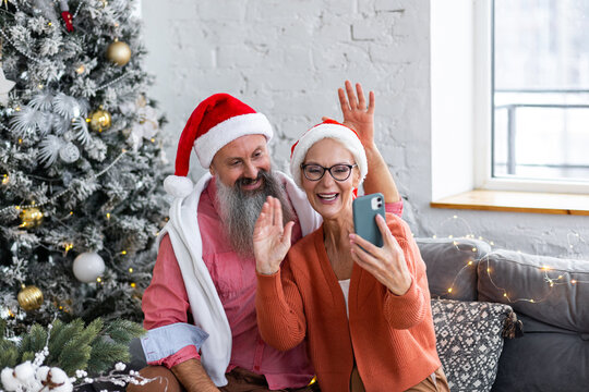 Happy couple of senior man and woman, mature people, pensioners doing video call with family, grandchildren on Christmas or new year. Holiday season, connection with beloved. Making selfie