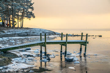 Winter icy pier sunset in Bygdøy, Norway. People sleeping in Hammock