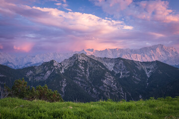 View from top of mountain in Alps in evening mood  with "Zugspitze" in background with  meadow in foreground
